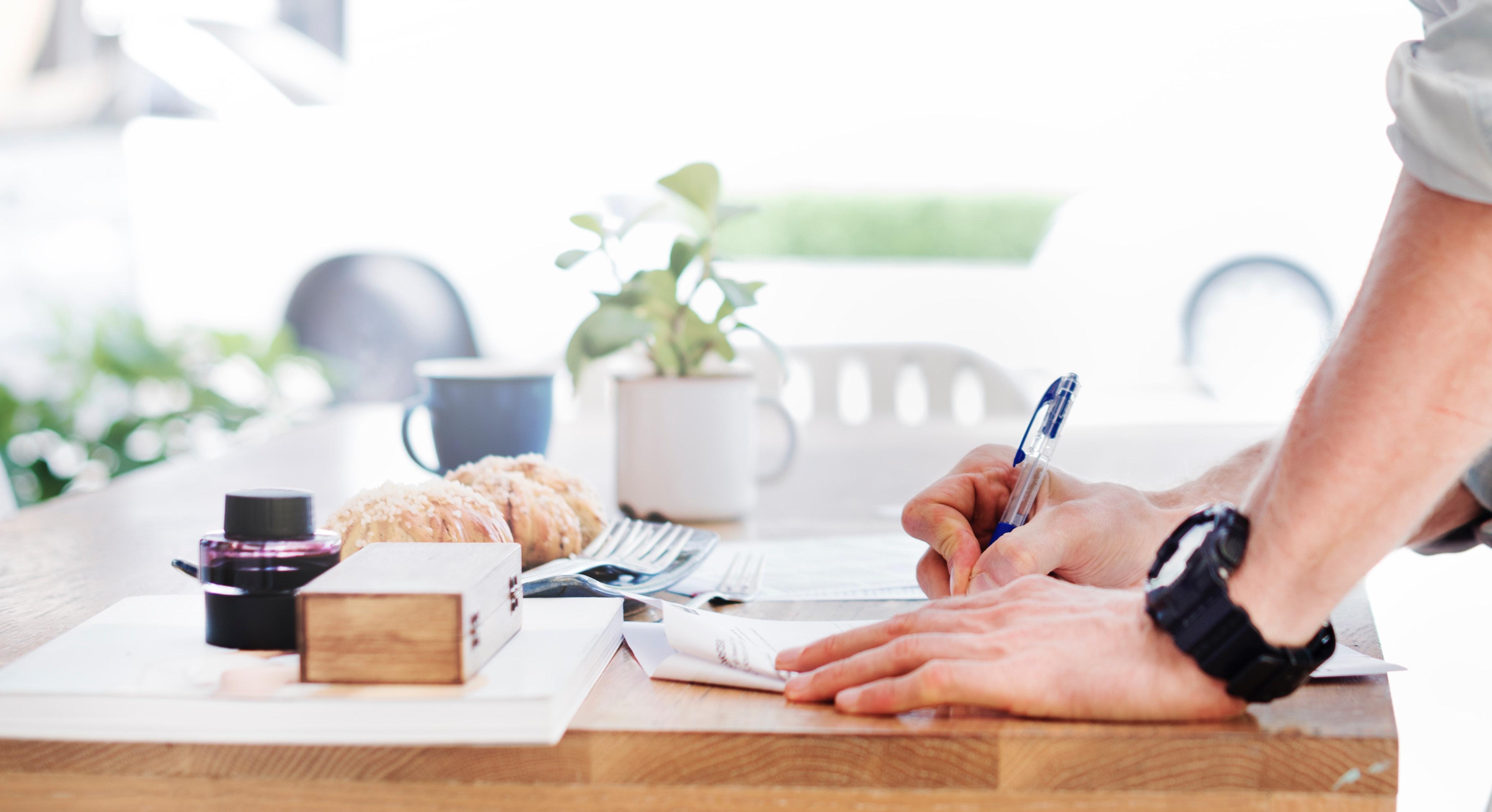 Man writing on desk pad